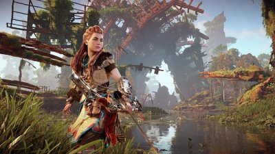 Horizon Zero Dawn Remastered-skærmbillede af Aloy med en bue foran en emtalstruktur